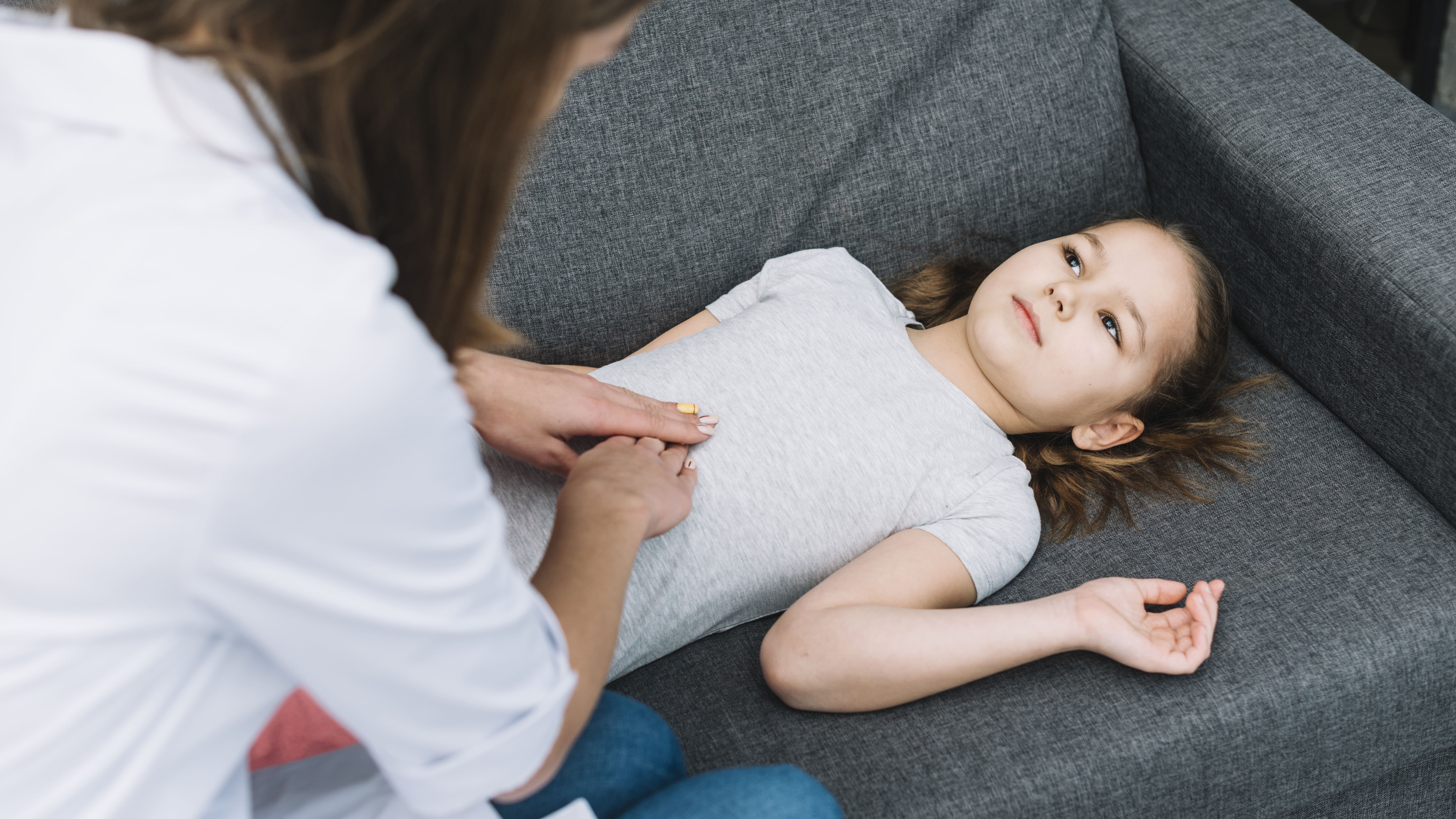 close-up-female-doctor-examining-patient-girl-lying-gray-sofa (1).jpg